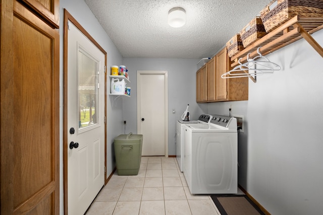 laundry area featuring light tile patterned floors, cabinets, independent washer and dryer, and a textured ceiling