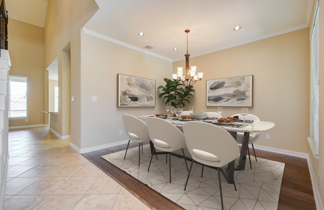 dining space featuring crown molding, a notable chandelier, and light wood-type flooring