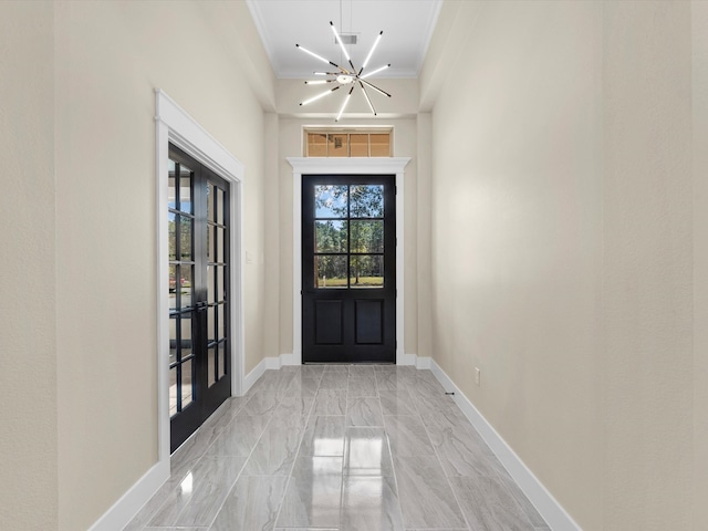 entryway featuring crown molding and a notable chandelier