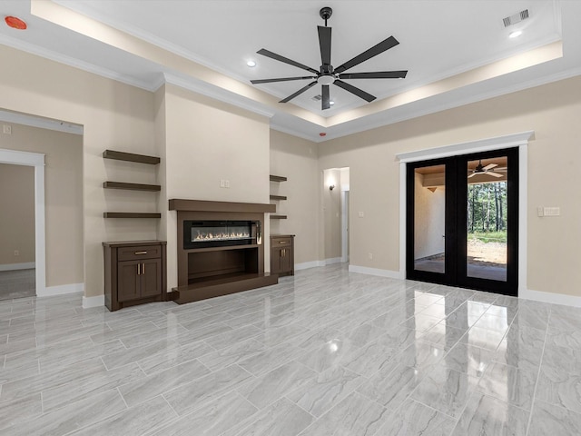 unfurnished living room with french doors, ornamental molding, ceiling fan, and a tray ceiling