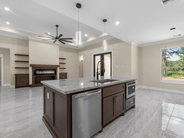 kitchen with sink, hanging light fixtures, light stone countertops, an island with sink, and stainless steel dishwasher