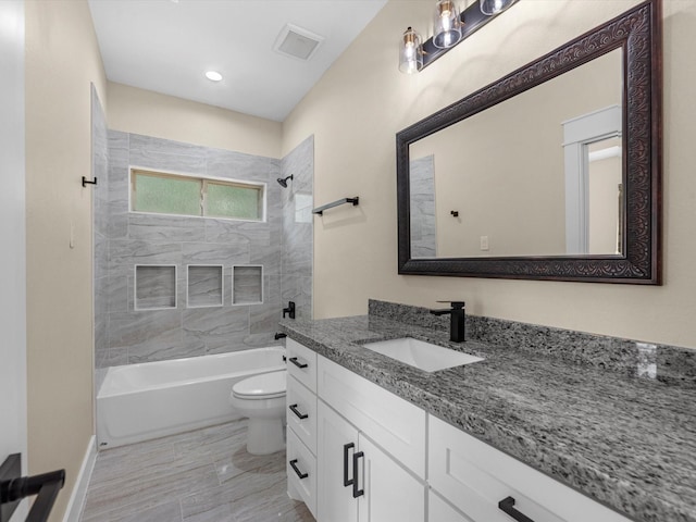 full bathroom with vanity, tiled shower / bath, and toilet