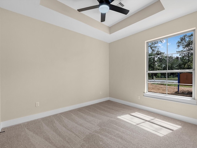 unfurnished room with carpet floors, a raised ceiling, and ceiling fan