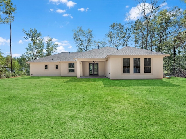 back of property featuring french doors, ceiling fan, and a lawn