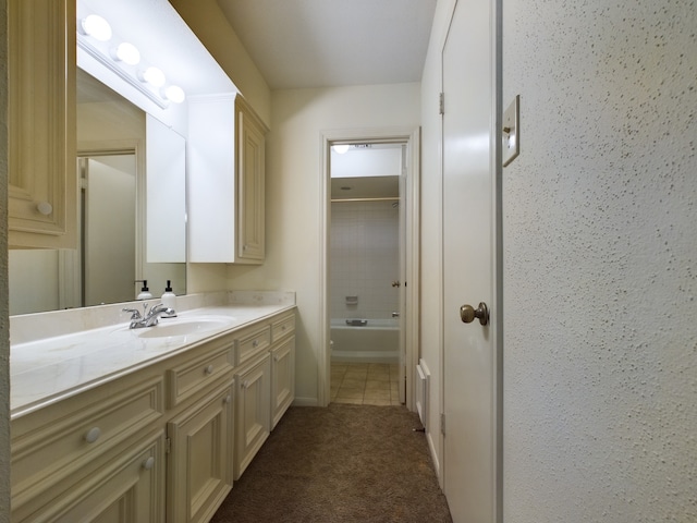 bathroom with vanity, tile patterned flooring, and tiled shower / bath