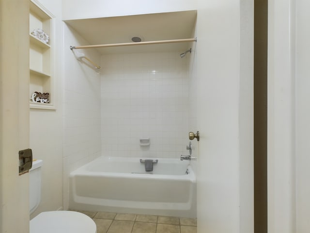 bathroom with tiled shower / bath, tile patterned floors, and toilet