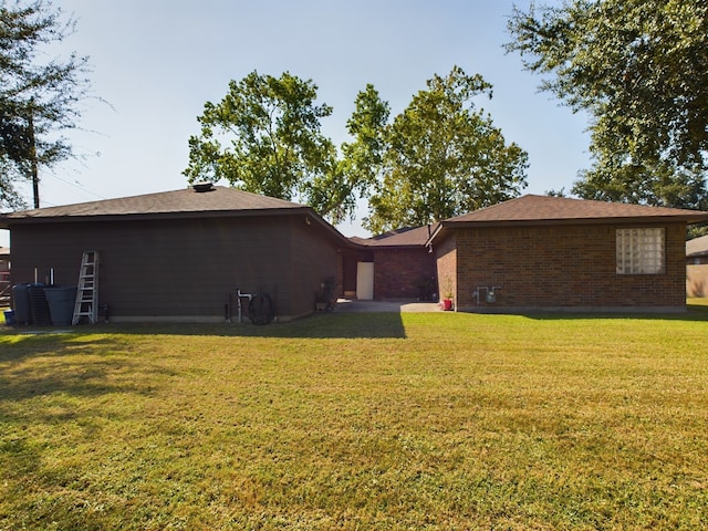 rear view of house featuring a yard