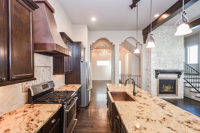 kitchen featuring custom exhaust hood, stainless steel appliances, sink, decorative light fixtures, and dark hardwood / wood-style floors