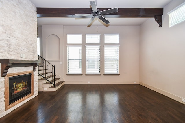 unfurnished living room with a fireplace, ceiling fan, plenty of natural light, and dark hardwood / wood-style flooring