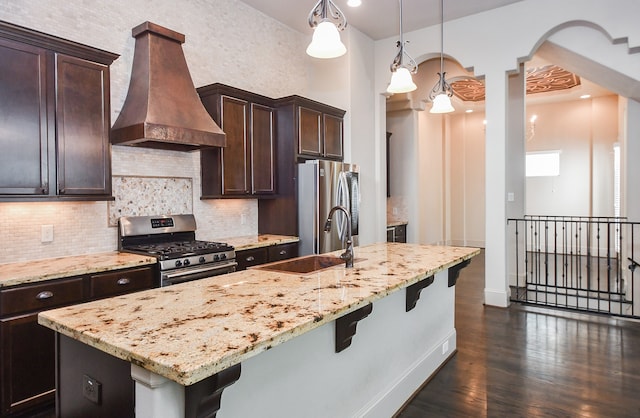 kitchen featuring dark brown cabinetry, stainless steel appliances, dark hardwood / wood-style floors, pendant lighting, and custom exhaust hood