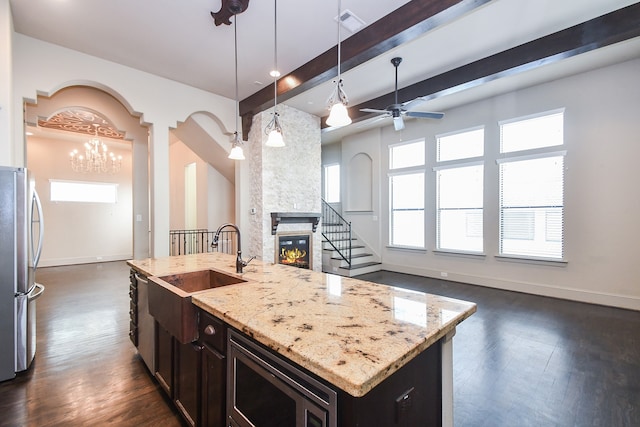 kitchen with a center island with sink, plenty of natural light, pendant lighting, and appliances with stainless steel finishes