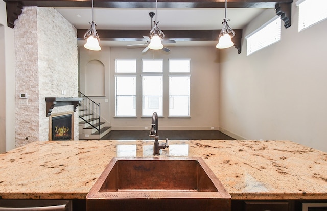 kitchen featuring a fireplace, hanging light fixtures, plenty of natural light, and sink