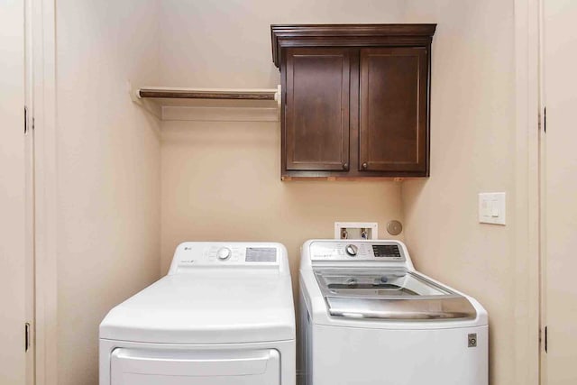 washroom with washing machine and dryer and cabinets