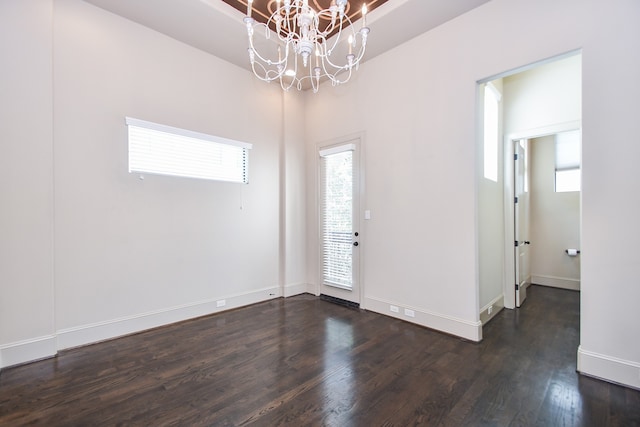 interior space with dark hardwood / wood-style floors and an inviting chandelier