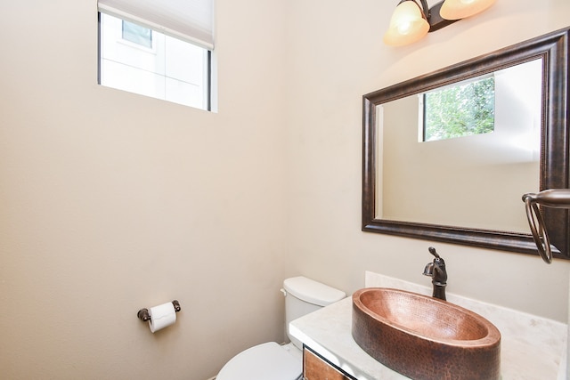 bathroom featuring vanity, a healthy amount of sunlight, and toilet