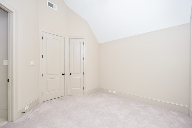 additional living space with light carpet and vaulted ceiling