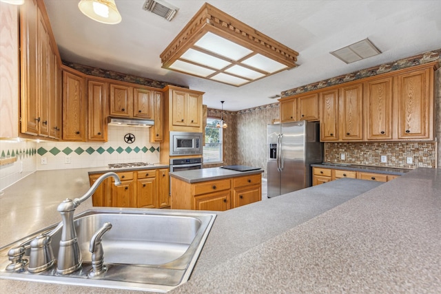 kitchen with decorative light fixtures, stainless steel appliances, backsplash, and sink