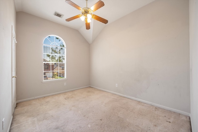 empty room featuring ceiling fan, light colored carpet, and vaulted ceiling