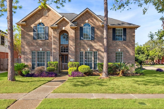 colonial-style house featuring a front yard