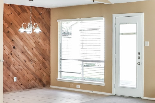 doorway to outside featuring an inviting chandelier and light tile patterned floors