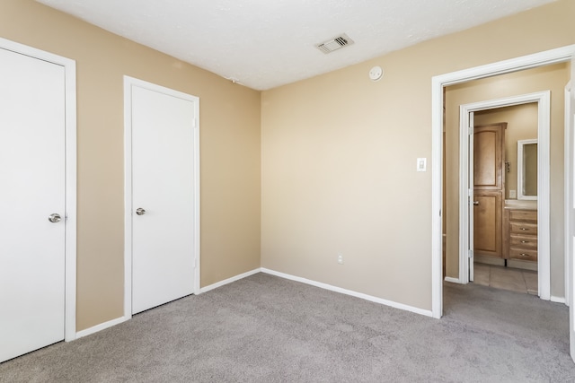 unfurnished bedroom featuring light carpet