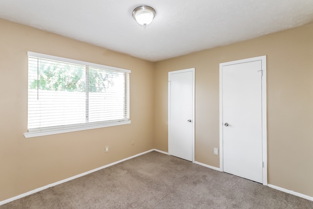 unfurnished bedroom with light colored carpet