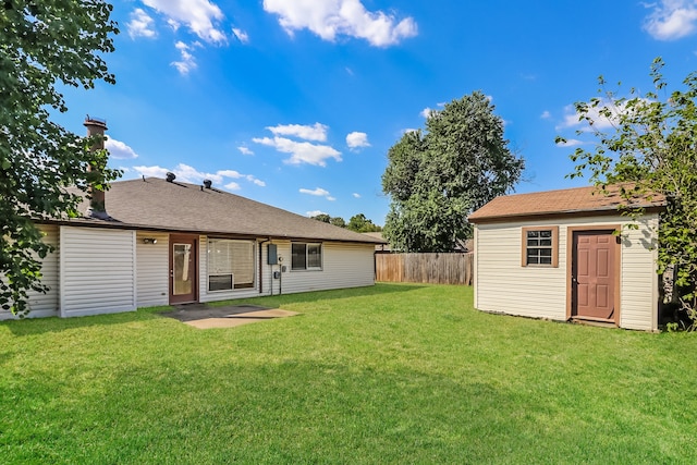 back of property with a shed, a yard, and a patio area