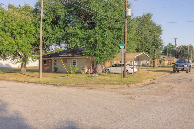 view of front of property featuring a front lawn and a carport