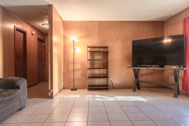 living room featuring wooden walls and light tile patterned floors