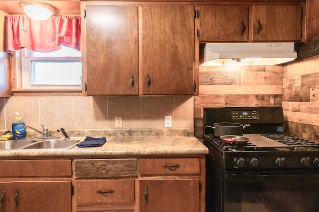 kitchen with black range with gas stovetop, backsplash, and sink