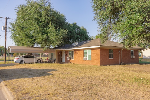 ranch-style house with a carport, cooling unit, and a front yard