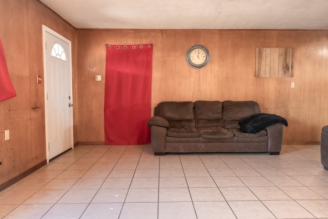 living room with light tile patterned floors and wooden walls