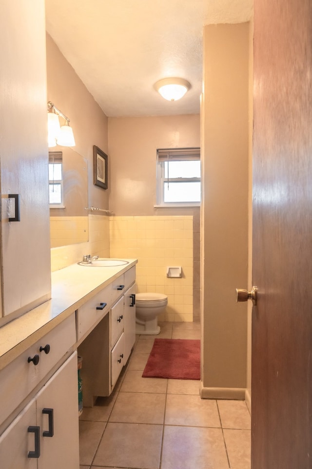 bathroom featuring tile patterned floors, vanity, tile walls, and toilet