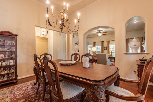 dining area with ornamental molding, dark hardwood / wood-style floors, and ceiling fan with notable chandelier