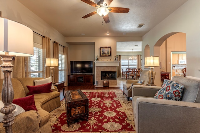 living room with a textured ceiling, ceiling fan with notable chandelier, plenty of natural light, and hardwood / wood-style flooring