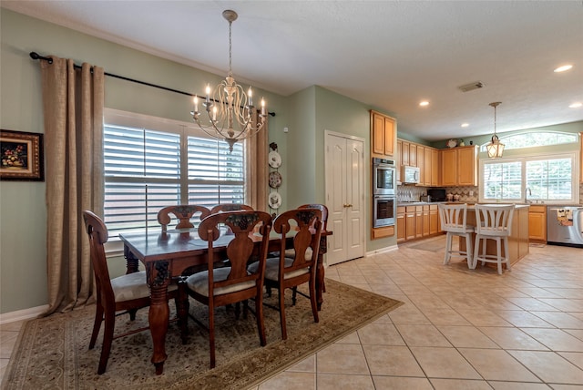 tiled dining space featuring sink and a chandelier