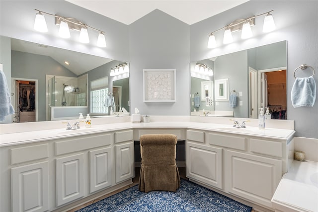 bathroom with vanity, lofted ceiling, and a shower with door