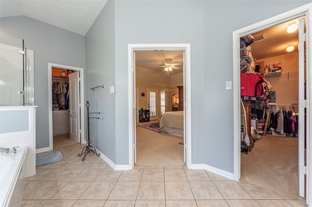 bathroom featuring lofted ceiling, tile patterned floors, ceiling fan, and a washtub