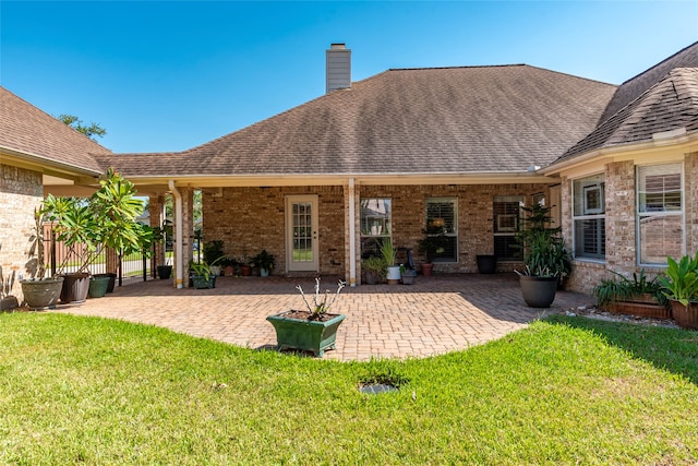 rear view of house featuring a patio and a lawn