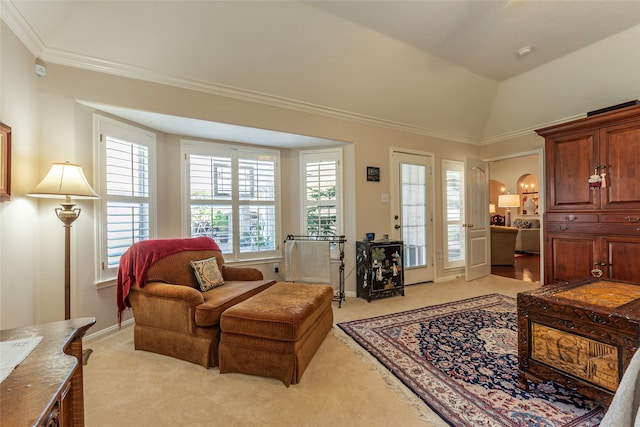 living area with ornamental molding, lofted ceiling, and light colored carpet