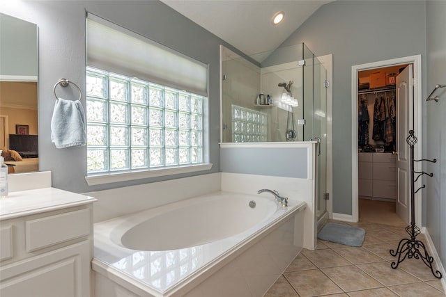 bathroom with vanity, separate shower and tub, vaulted ceiling, and tile patterned floors