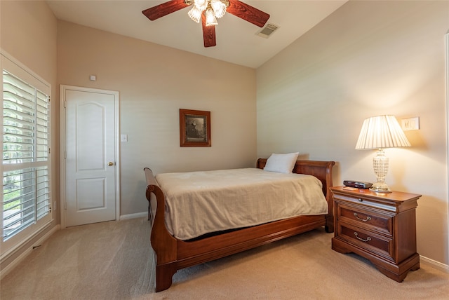 bedroom featuring ceiling fan, vaulted ceiling, and light colored carpet