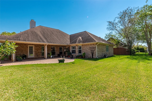 rear view of property with a patio, a fire pit, and a lawn