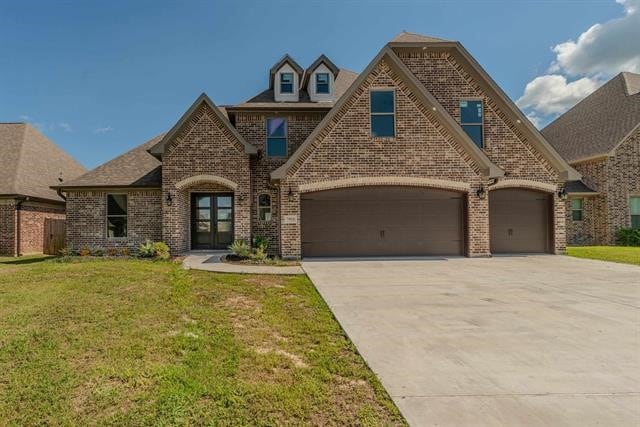 view of front of home featuring a garage and a front lawn