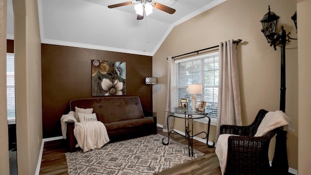 living area with ceiling fan, hardwood / wood-style flooring, crown molding, and vaulted ceiling