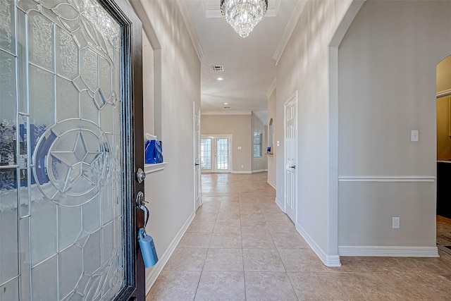 hall with light tile patterned flooring, french doors, crown molding, and a chandelier