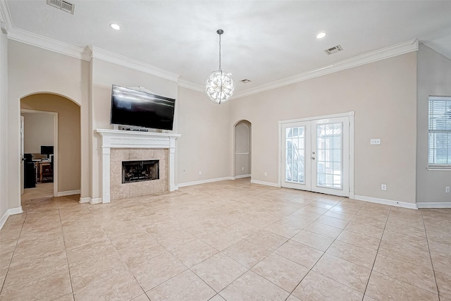 unfurnished living room featuring a tiled fireplace, crown molding, and light tile patterned floors