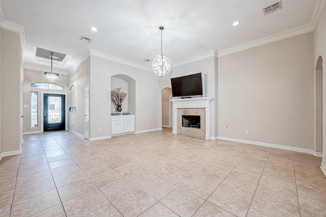 unfurnished living room with a notable chandelier, light tile patterned floors, ornamental molding, and a tile fireplace