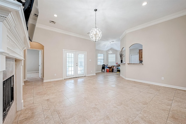 unfurnished living room featuring a fireplace, french doors, a chandelier, and crown molding