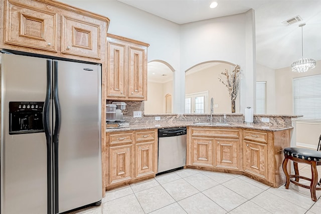 kitchen with backsplash, sink, light stone countertops, a notable chandelier, and stainless steel appliances